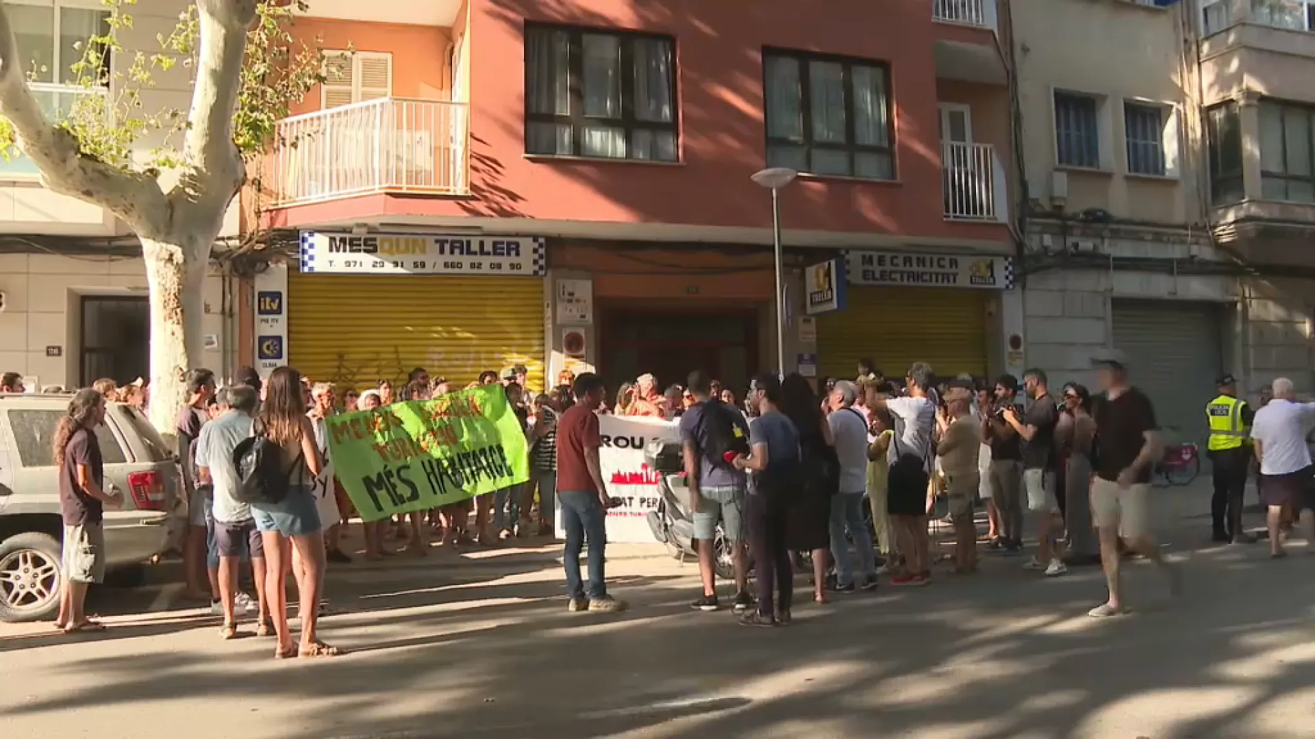 Mig centenar de persones protesten davant un edifici dedicat íntegrament al lloguer turístic il·legal